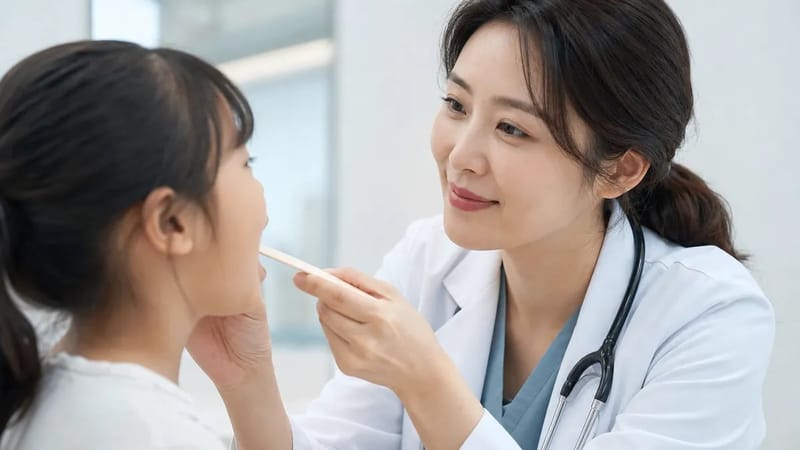 전문의가 환자의 목 상태를 살피며 진료하는 장면입니다.
