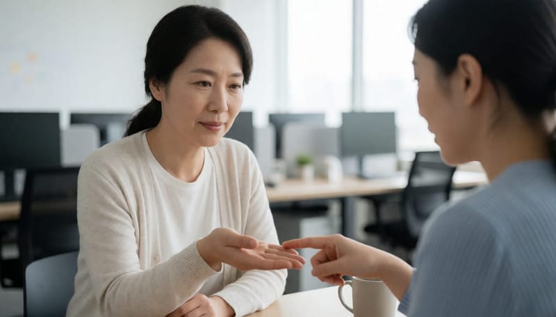 동료가 손등의 붉은 점을 살펴보며 가리키는 사무실 장면