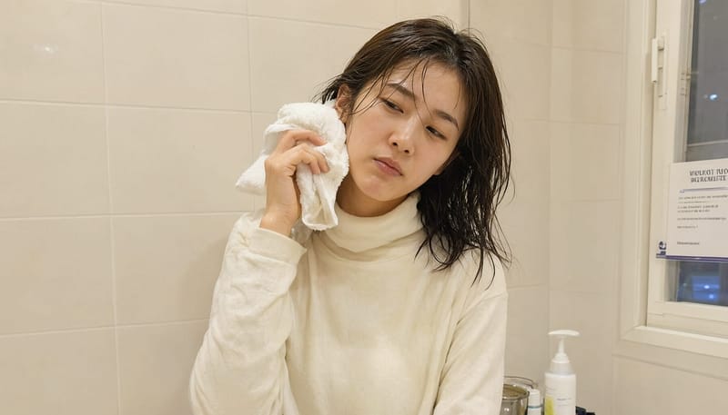 샤워 후 귀에 물이 남은 느낌에 머리를 기울이고 수건으로 닦는 20대 여성