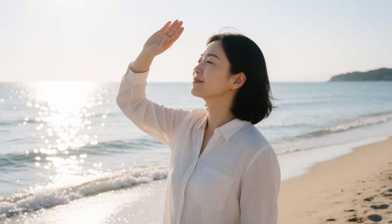 햇빛 눈부심 가리는 해변가 여성