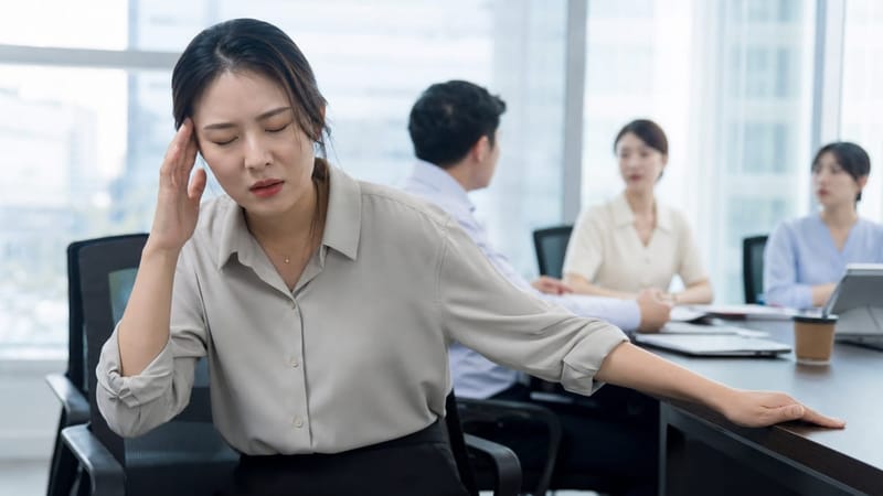 회의 중 어지럼을 느껴 잠시 눈을 감고 안정을 취하는 직장인