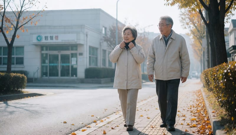 일교차가 큰 가을 아침, 두 어르신이 산책하며 보건소 쪽으로 걸어가는 모습