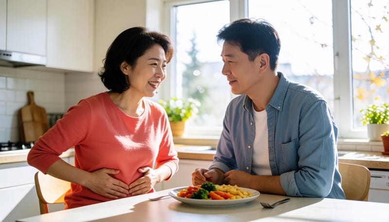 식사 후 상복부를 감싸쥐고 괴로워하는 여성의 모습