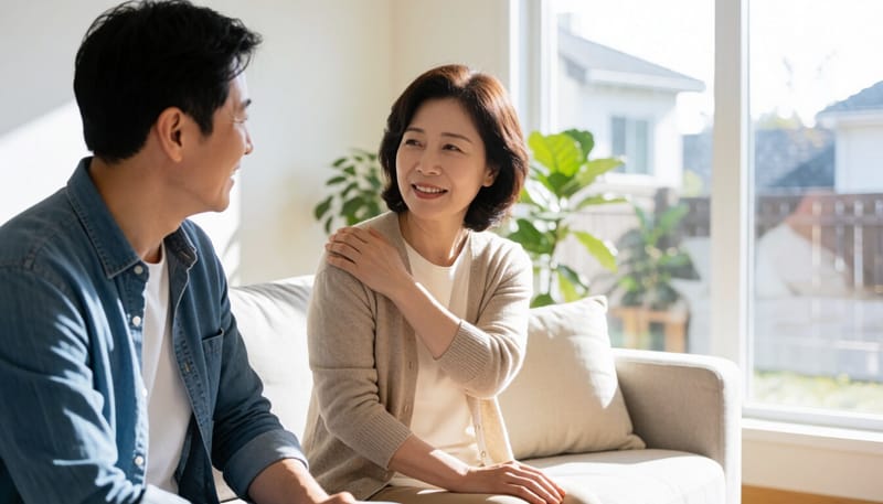 집에서 어깨를 붙잡고 통증을 호소하는 중년 여성