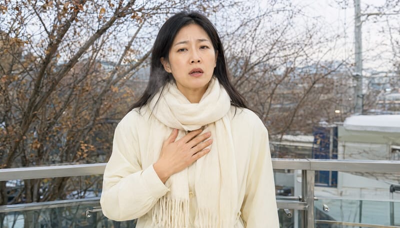 찬 바람 부는 가을 아침 가슴에 손을 올린 중년 여성