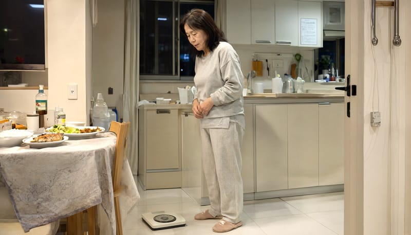 체중계를 보며 식단을 고민하는 여성